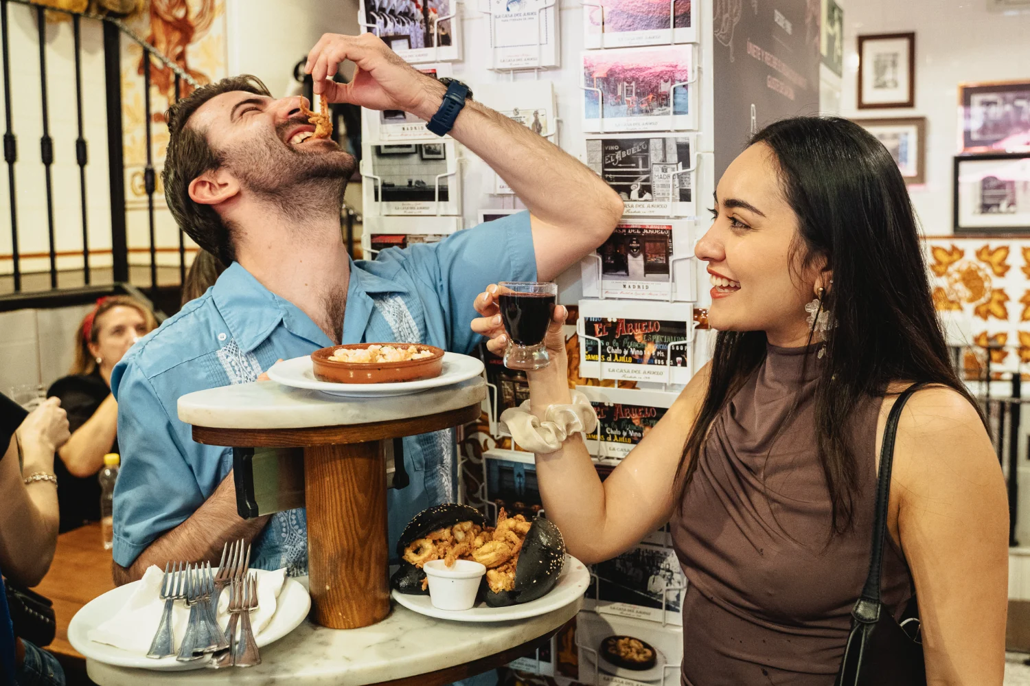 Food tour guest being playfully fed gambas at El Abuelo restaurant during a Tipsy Tapas Tour of Madrid