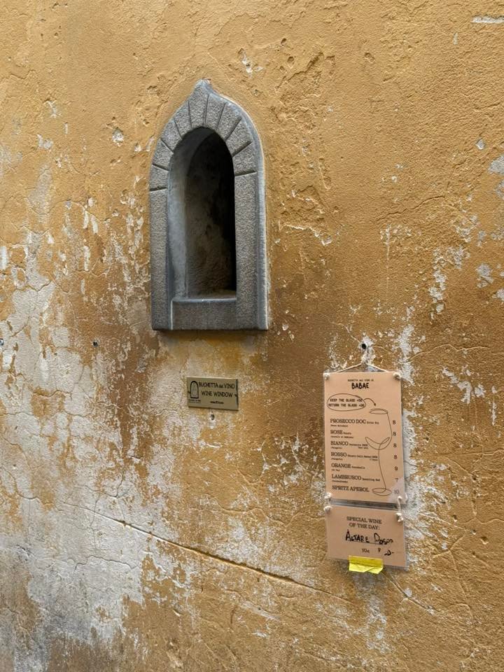 Wine window in Florence with a menu affixed outside